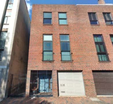 1015 Lombard Street, a 1978 brick rowhouse with a white garage door