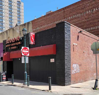 The nomination's photograph of the Juniper Street frontage of 1320-22 Walnut Street: a brick storefront with an adult boutique sign